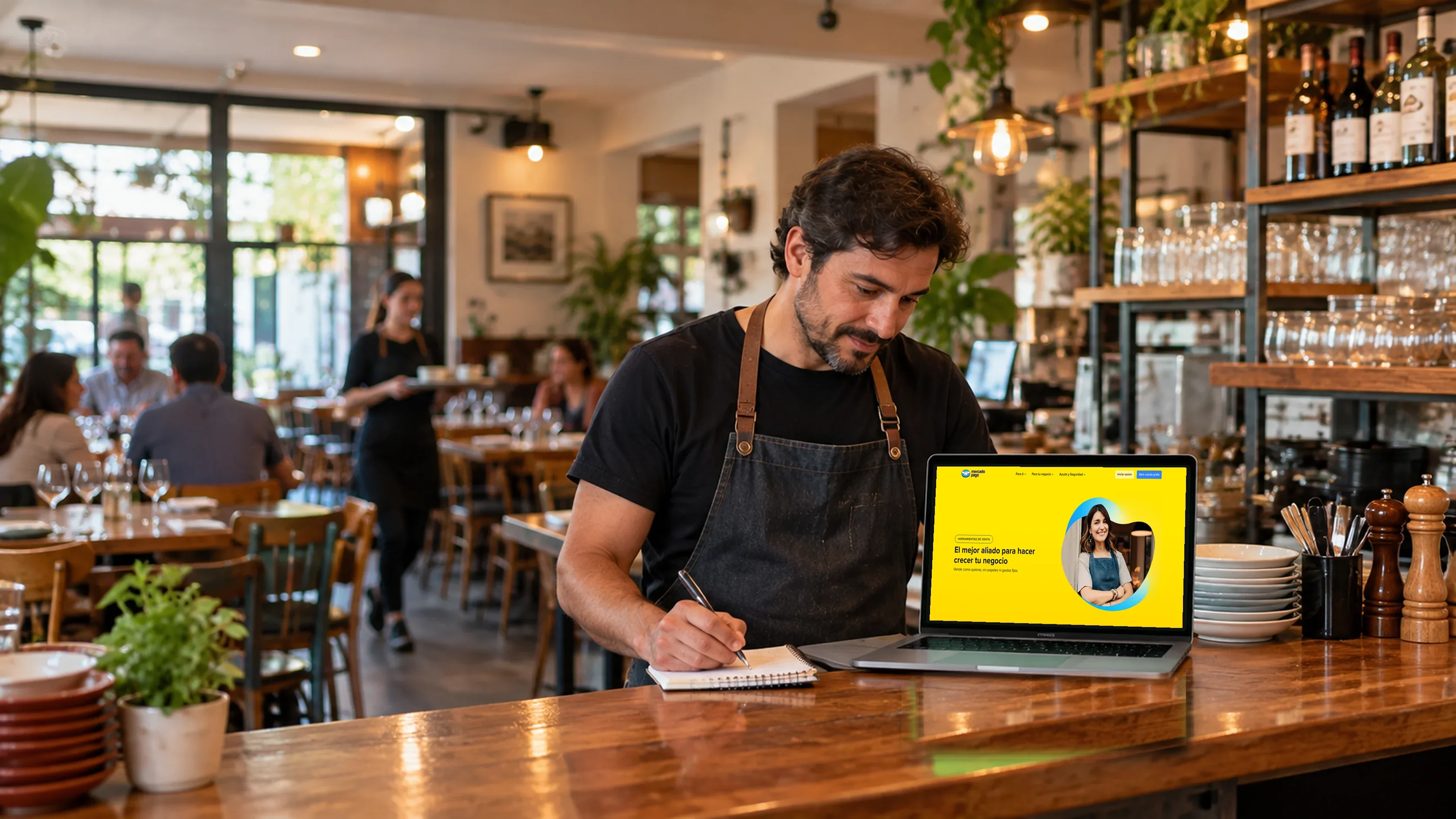 Dueño de un restaurante revisando los pagos de Mercado Pago de su página web en el notebook